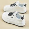 Womens white low top sneakers with red laces showcasing the side profile of the shoe