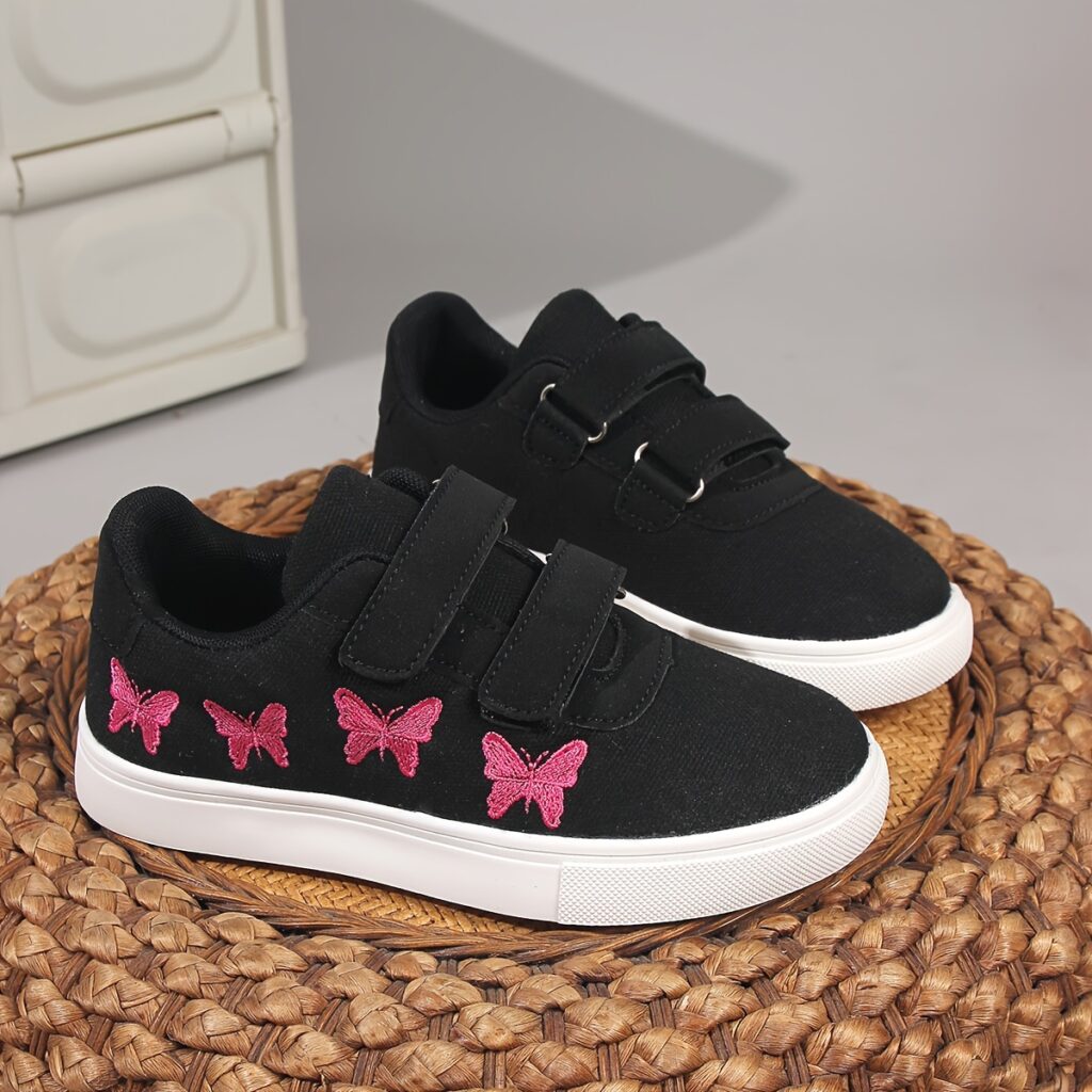 Newness Butterfly Breeze Sneakers: Vintage-inspired black canvas low-top sneakers with pink butterfly accents, hook-and-loop closures, and durable rubber sole, perfect for boys and girls.