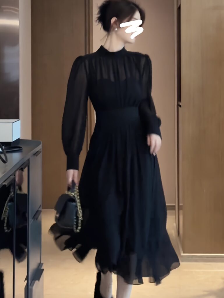 Model wearing a flowing chiffon midi dress in deep navy blue, ideal for fall. The dress features a flattering silhouette and elegant design.