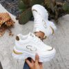 Newness City Chic White Lace Up Sneakers A pair of stylish white lace up sneakers with a modern design showcasing comfort and versatility