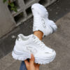 Newness City Chic White Lace Up Sneakers A pair of stylish white lace up sneakers with a modern design showcasing comfort and versatility