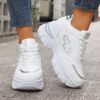 Newness City Chic White Lace Up Sneakers A pair of stylish white lace up sneakers with a modern design showcasing comfort and versatility