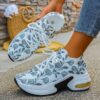 Newness Botanical Breeze Floral Slip On Sneakers White canvas sneakers adorned with a vibrant floral print showcasing breathable design and lightweight comfort