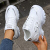 Newness City Chic White Lace Up Sneakers A pair of stylish white lace up sneakers with a modern design showcasing comfort and versatility